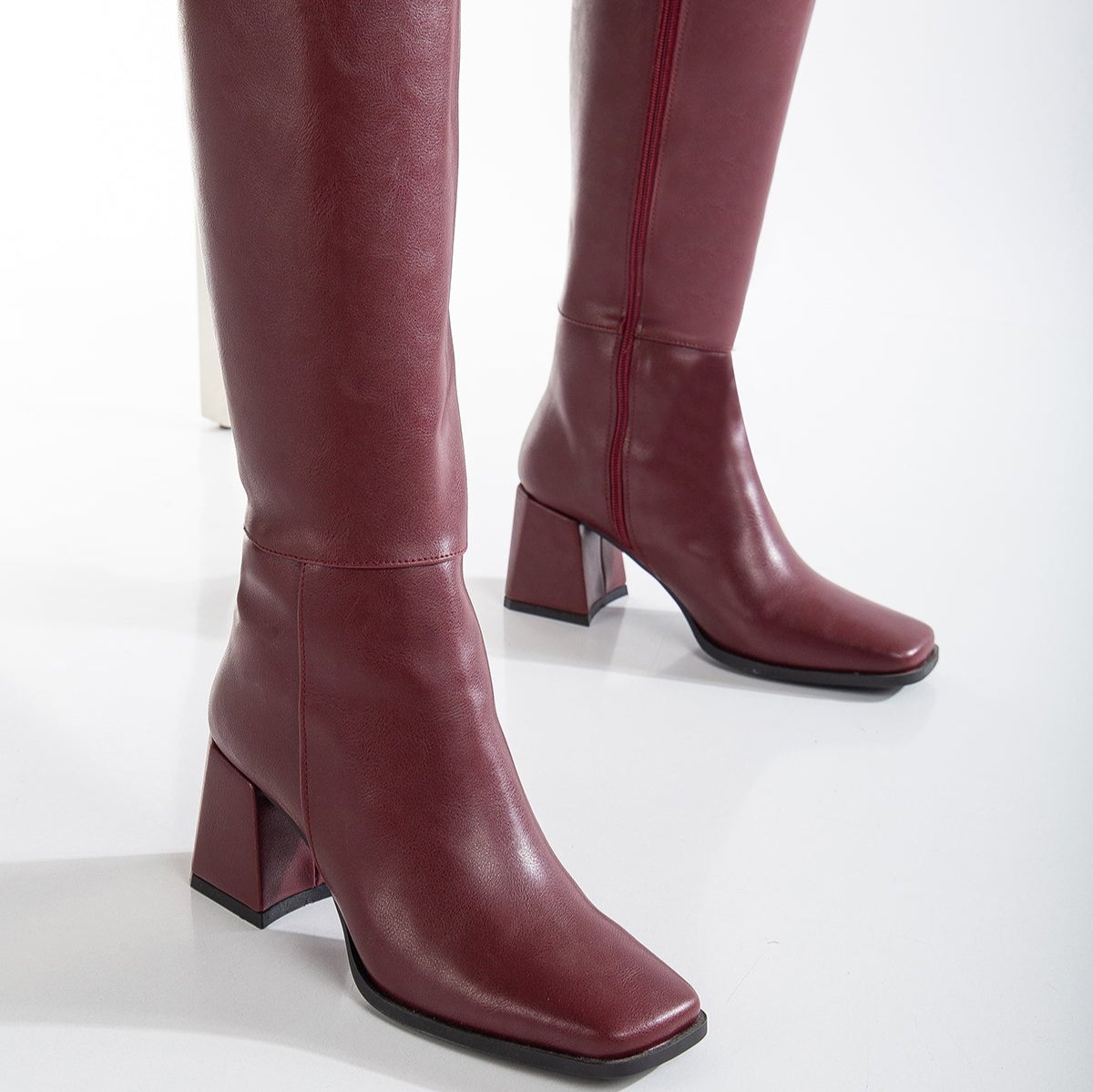 Vegan knee-high boots, black knee-high boots, burgundy knee-high boots, sustainable knee-high boots, cruelty-free knee-high boots, eco-friendly knee-high boots, vegan leather knee-high boots, women's knee-high boots, stylish knee-high boots, faux leather knee-high boots.